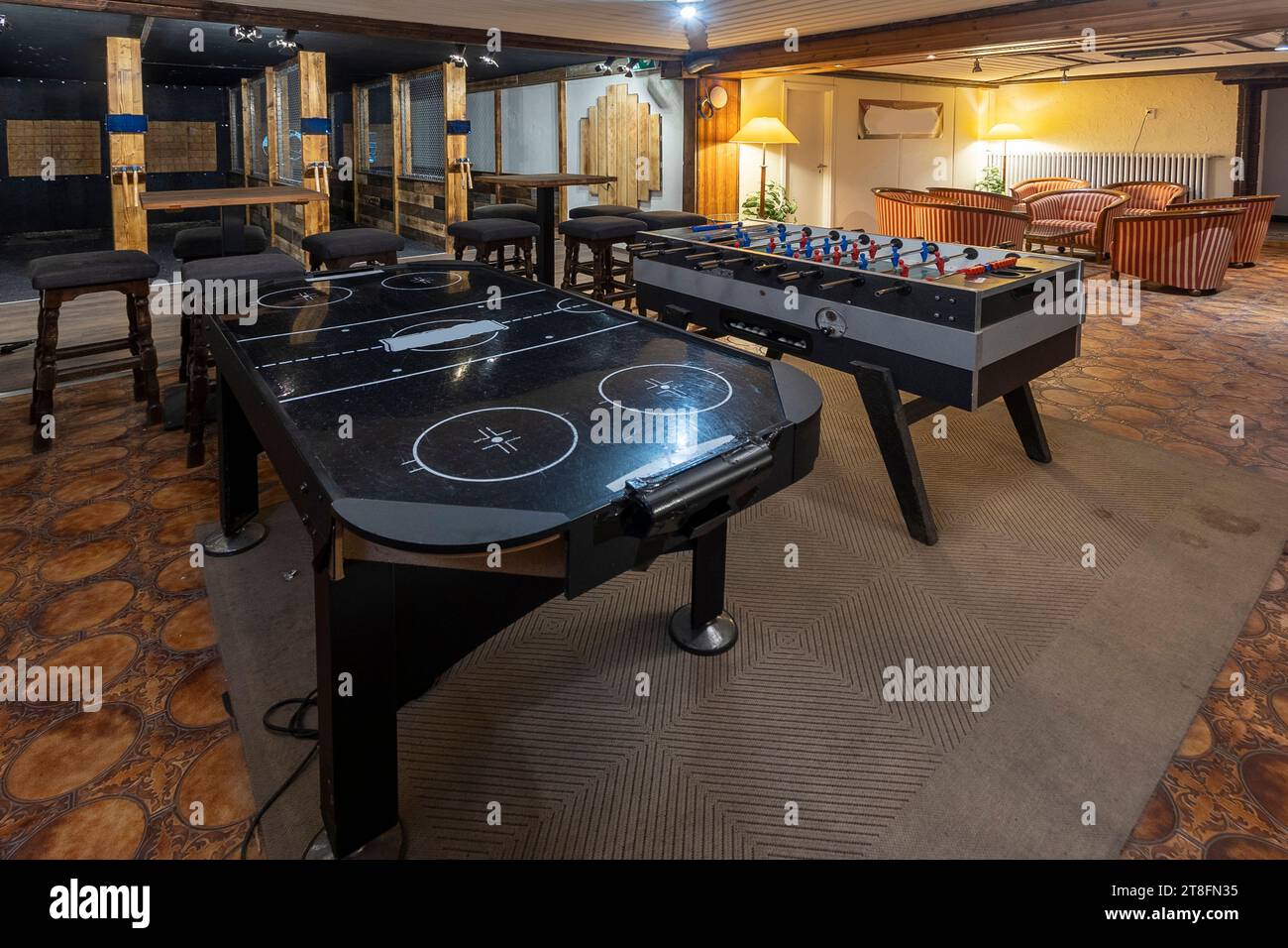 Un intérieur de casino haut de gamme montrant plusieurs tables de jeux de cartes avec un éclairage sophistiqué et un décor élégant. Banque D'Images