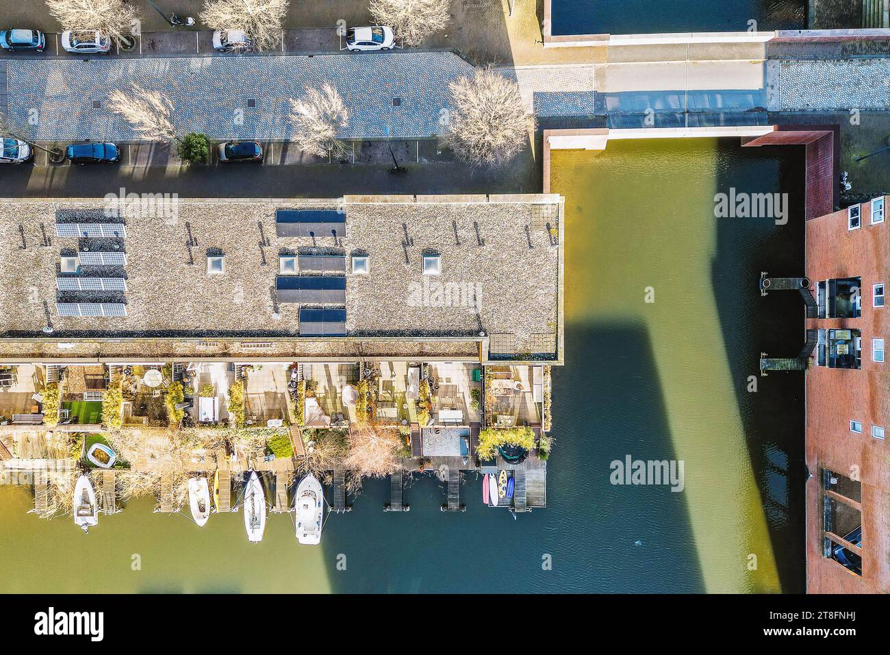 Vue aérienne des bateaux amarrés au port et panneaux solaires sur le toit du bâtiment en ville pendant la journée ensoleillée Banque D'Images