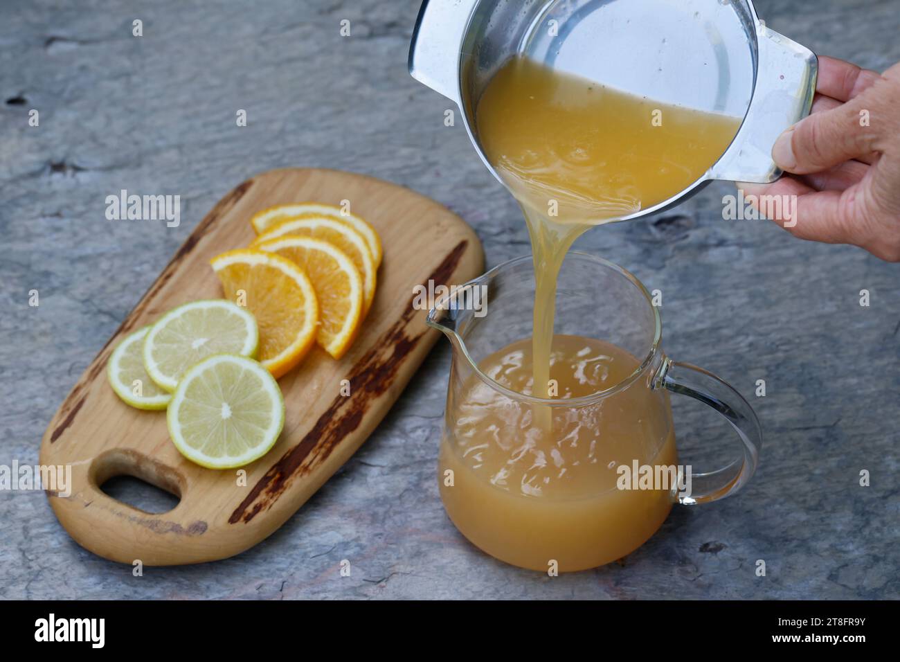 Eistee, EIS-Tee aus Kräutertee gemischt mit Apfelsafe, Saft von Orange, Saft von Zitrone, Iced Tea, Ice tea Schritt 3 : Saft einer frischen Orange und Banque D'Images