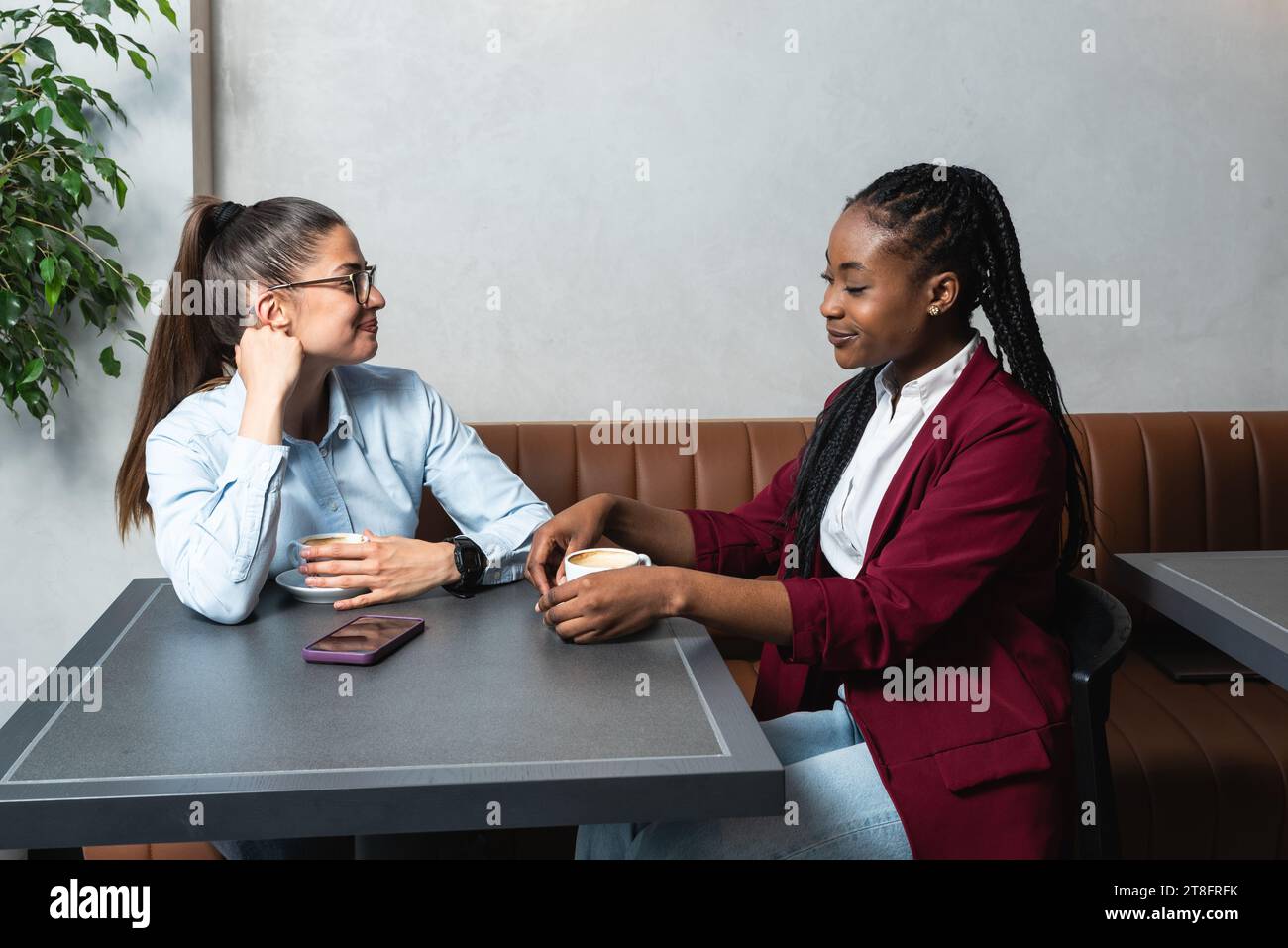 Deux jeunes collègues d'affaires prenant une pause dans la cafétéria voisine buvant un café parlant de la vie privée, pour mieux se connaître. Staf Banque D'Images