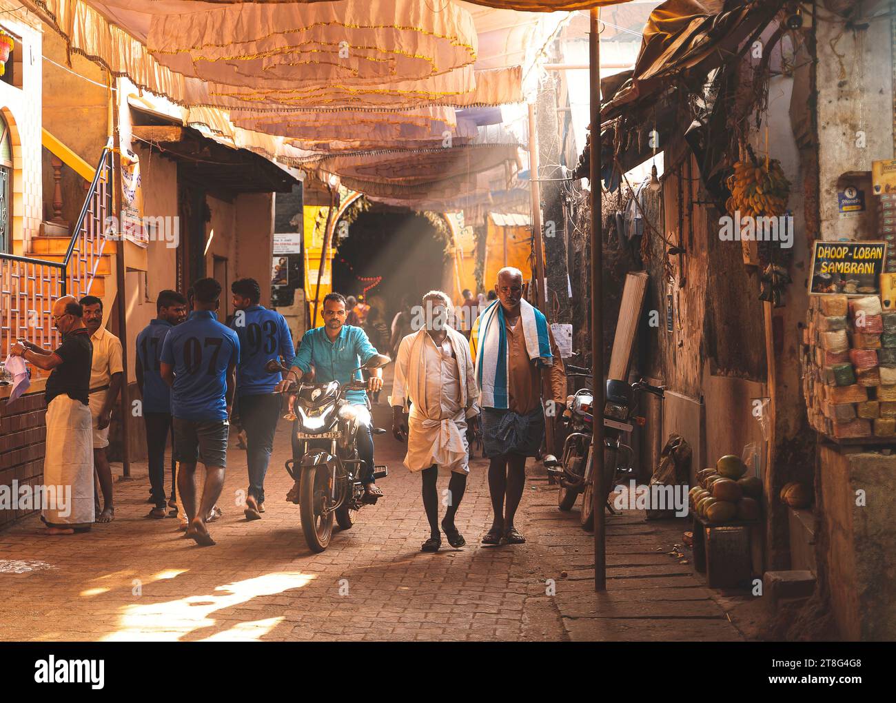 Gokarna, Inde - 21 février 2023 - matin à Gokarna, des gens marchent le long d'une rue éclairée par la lumière du soleil. Etat du Karnataka, Inde Banque D'Images
