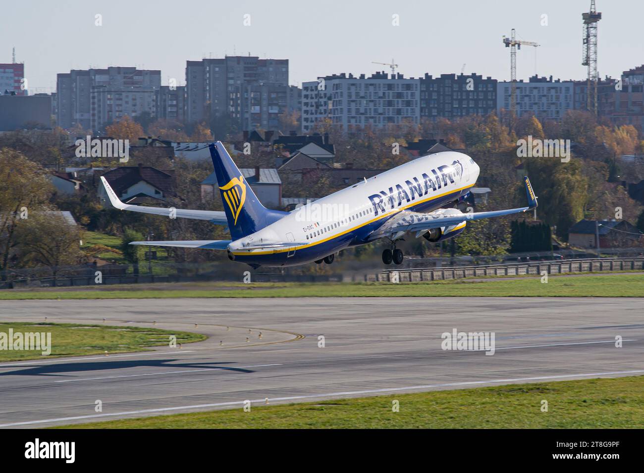 Boeing 737-800 de Ryanair décollant de l'aéroport de Lviv avec la ville en arrière-plan Banque D'Images