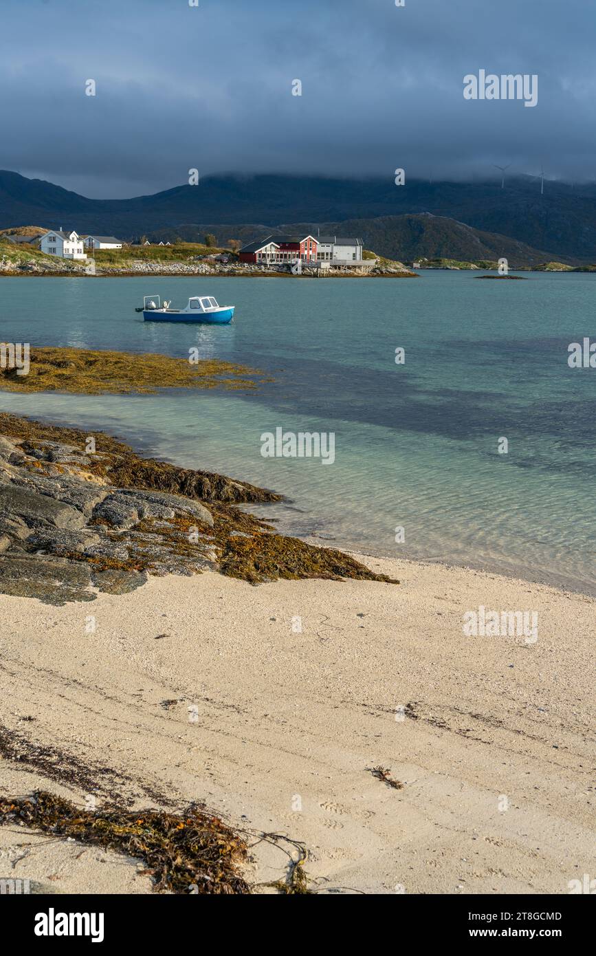Bateau à rames près de la plage de sable blanc de Sommarøy à Troms, Norvège. En arrière-plan les eaux turquoises de l'Atlantique avec des îles et un hangar à bateaux Banque D'Images