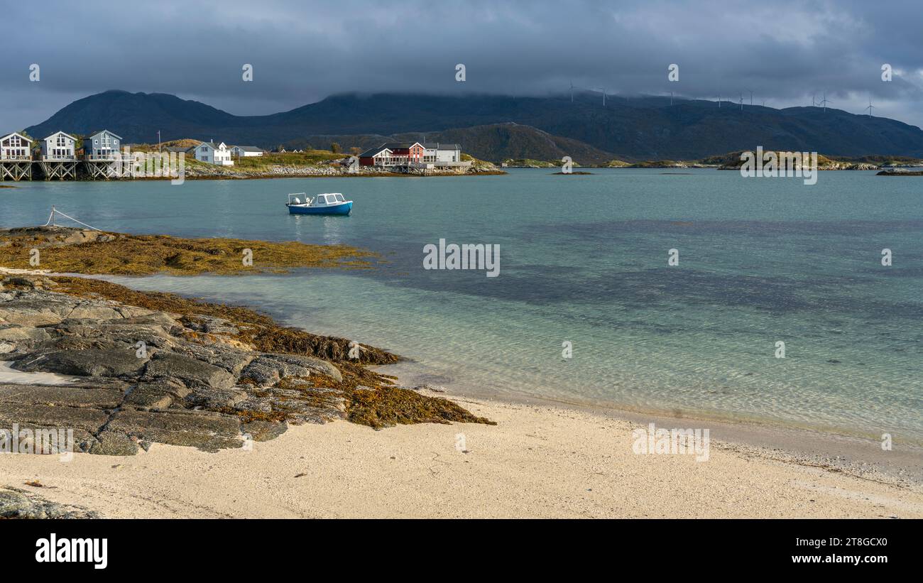 Bateau à rames près de la plage de sable blanc de Sommarøy à Troms, Norvège. En arrière-plan les eaux turquoises de l'Atlantique avec des îles et un hangar à bateaux Banque D'Images