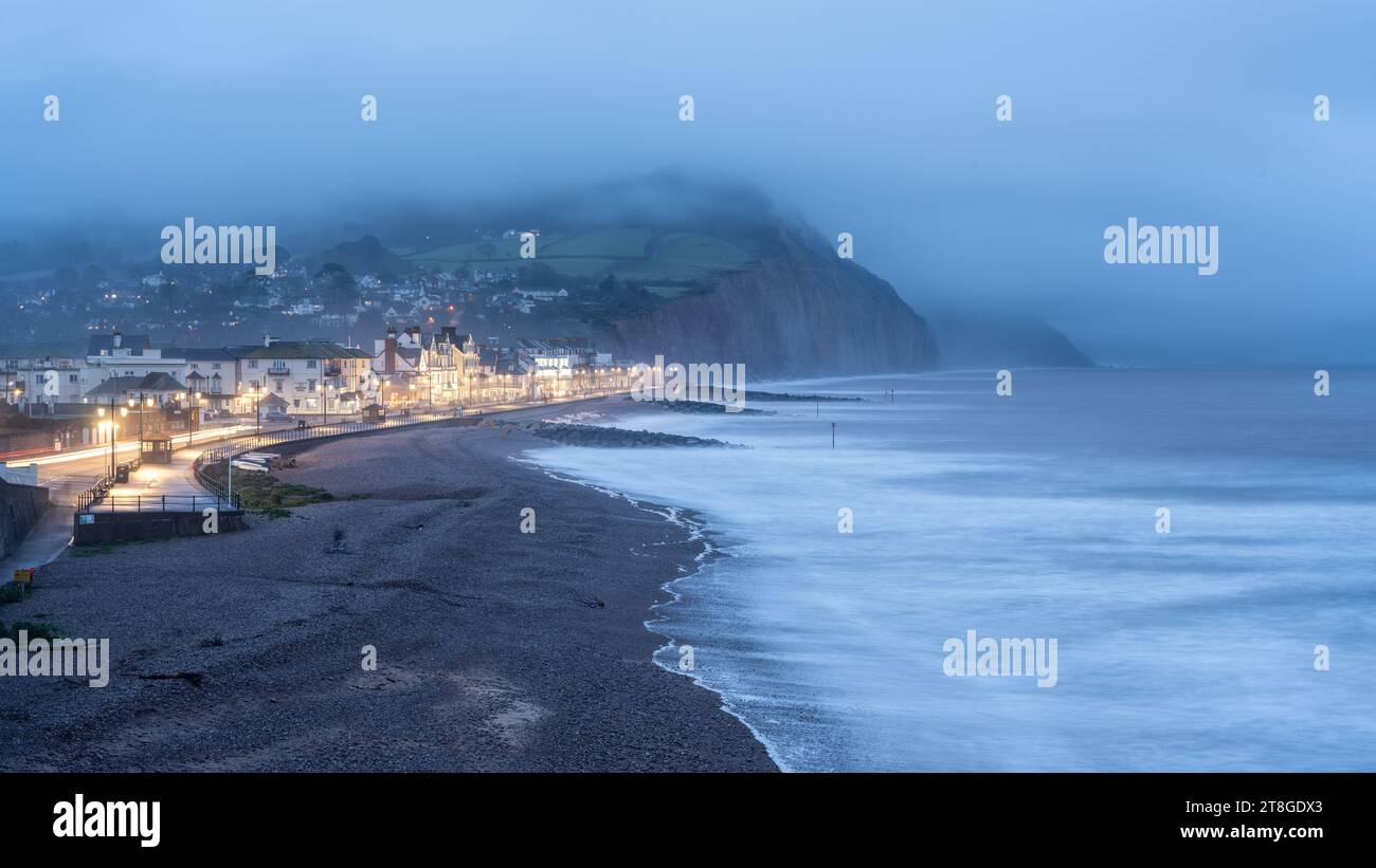 L'esplanade du front de mer est éclairée la nuit dans la ville balnéaire de Sidmouth, sur la côte jurassique du Devon. Banque D'Images