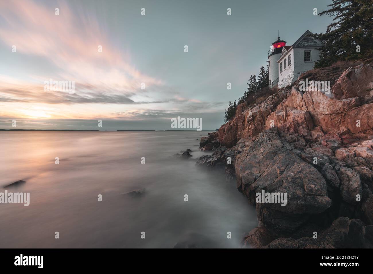 Phare du Maine au coucher du soleil avec rochers et océan dans les arbres Banque D'Images