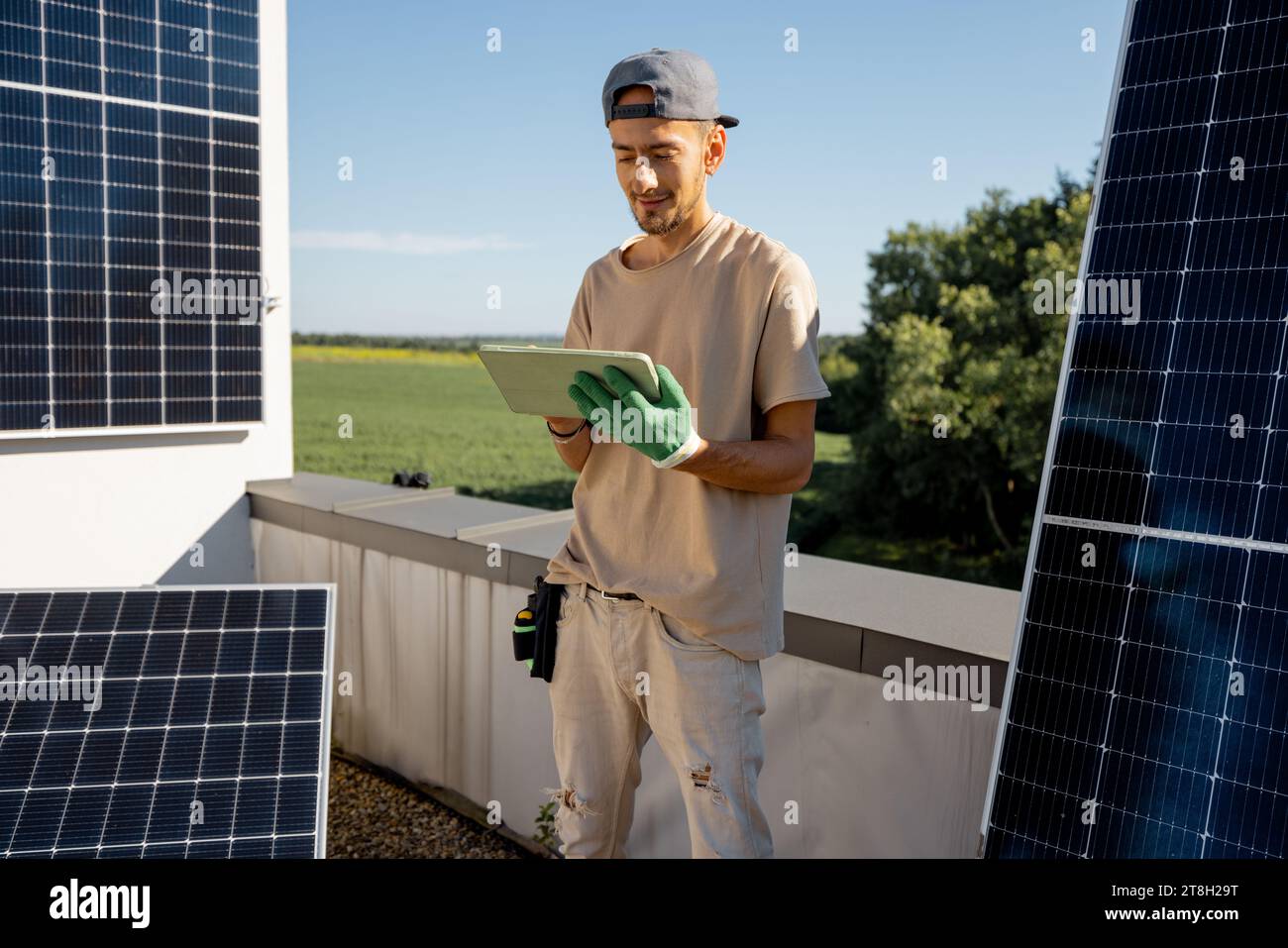Technicien avec une tablette numérique sur un toit avec centrale solaire Banque D'Images