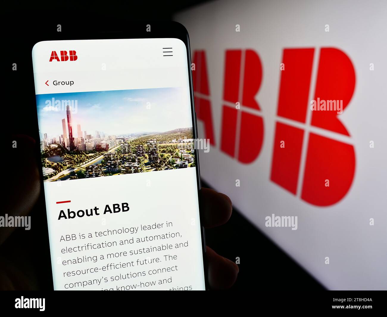 Personne détenant un téléphone cellulaire avec la page Web de la société d'équipement électrique ABB Ltd. Devant le logo de l'entreprise. Concentrez-vous sur le centre de l'écran du téléphone. Banque D'Images