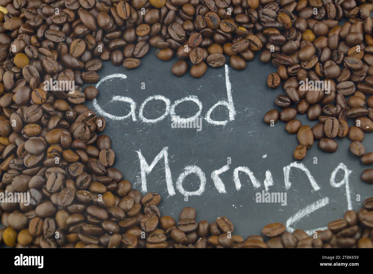 Grains de café torréfiés sur tableau noir lettrage bonjour Banque D'Images