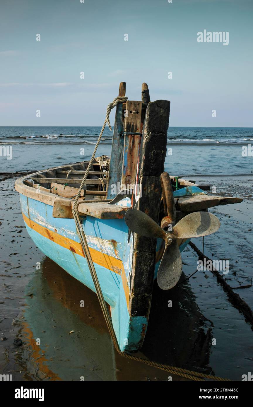 un bateau de pêche est penché sur le rivage Banque D'Images