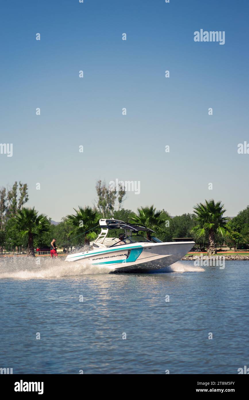 Queretaro, Mexique, 23 11 20, photo de sports nautiques d'un bateau de sport blanc tirant un wakeboarder à travers un lac par une journée ensoleillée, ciel bleu Banque D'Images