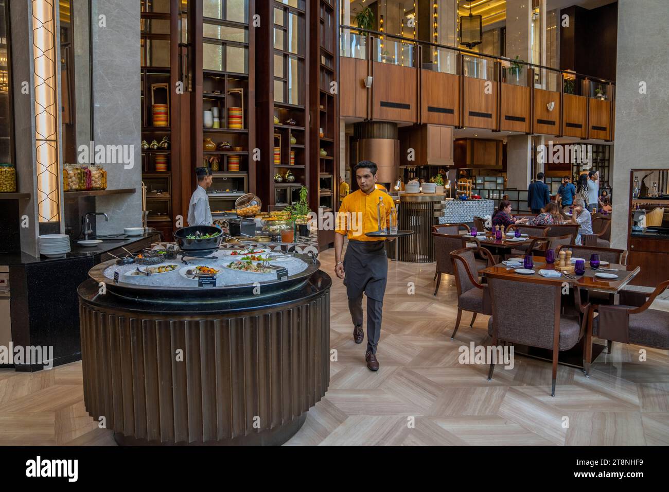 Priyesh Shinde carries Veen bottled water before serving it to customers at the Conrad Hilton hotel in Pune, India, Thursday, May 4, 2023. Veen, a fine water that is bottled in Bhutan, is primarily sold in luxury restaurants and hotels in India. (AP Photo/Dar Yasin) Banque D'Images