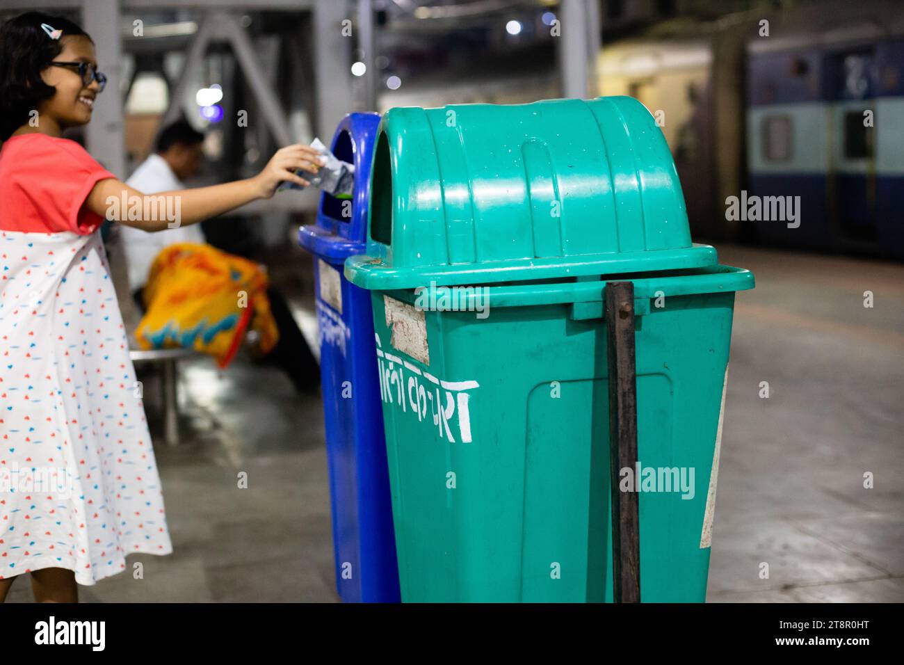 Dhanbad, Jharkhand, Inde - 26 octobre 2023 : poubelle de couleur verte et bleue sur la plate-forme des chemins de fer indiens utilisée par un enfant Banque D'Images