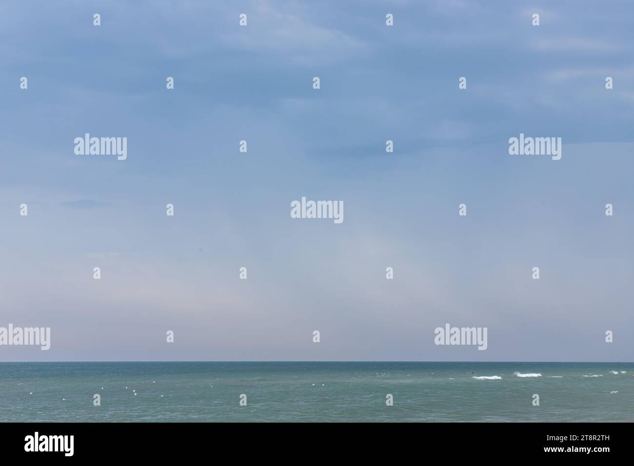 Une grande et forte onde de tempête de couleur turquoise avec des éclaboussures de mousse blanche coule et se brise sur le rivage. Banque D'Images