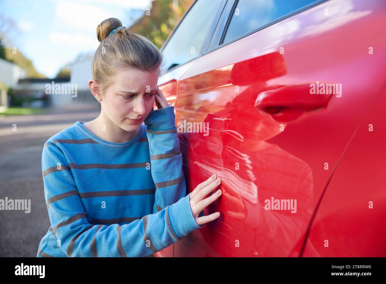 Jeune conducteur adolescent inquiet regardant la voiture endommagée après un accident Banque D'Images