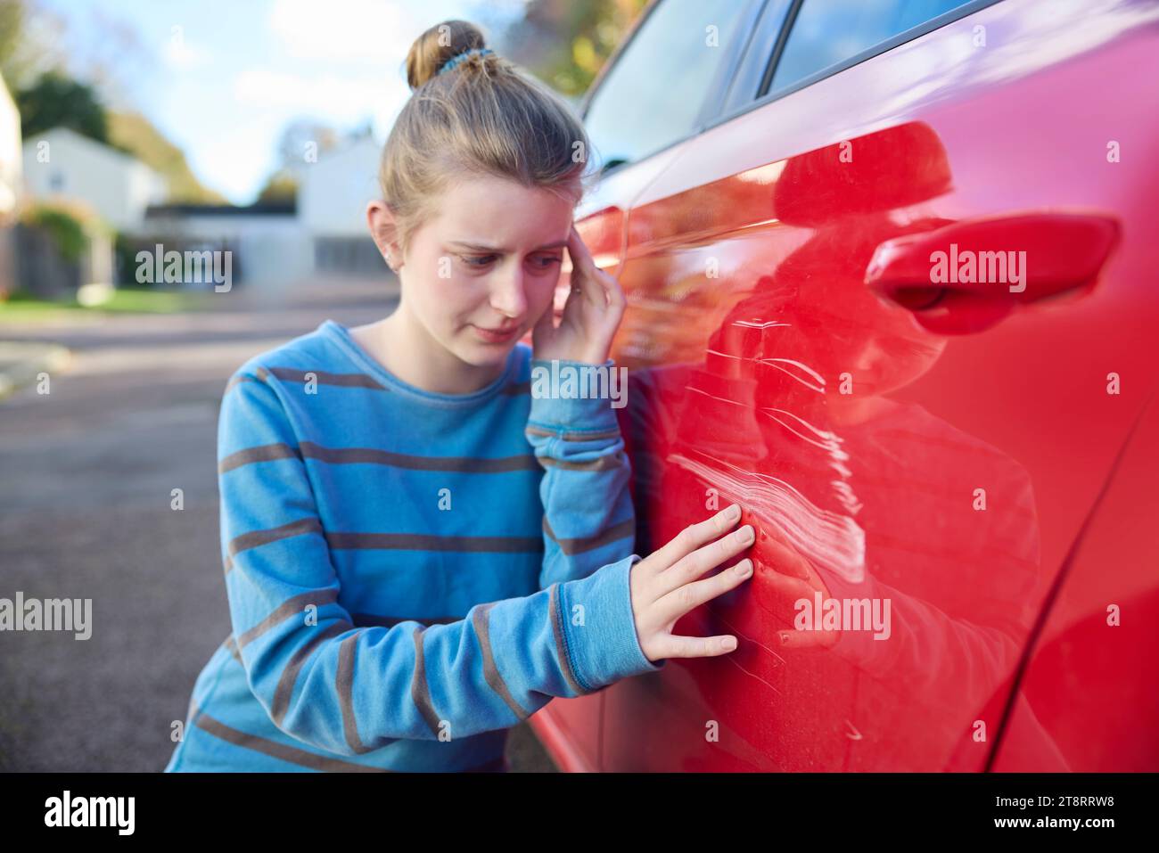 Jeune conducteur adolescent inquiet regardant la voiture endommagée après un accident Banque D'Images