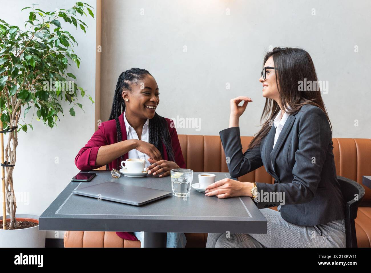 Deux jeunes collègues d'affaires prenant une pause dans la cafétéria voisine buvant un café parlant de la vie privée, pour mieux se connaître. Staf Banque D'Images