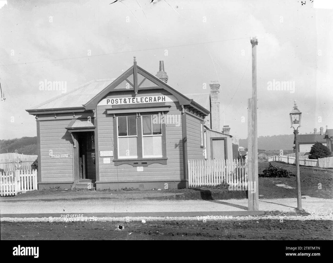 Raglan, New Zealand Post Office, 1910, Raglan, New Zealand Post Office. Un bâtiment en bois, avec signe 'Post & Telegraph' au-dessus de la fenêtre. Il y a un lampadaire sur la droite, et un panneau à gauche de la porte d'entrée «Agence du département d'assurance-vie du gouvernement». Prise en 1910 Banque D'Images