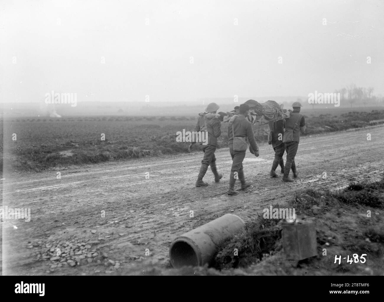 Amenant les blessés sous le feu pendant la première Guerre mondiale, en France, les porteurs de brancard transportent un soldat blessé le long d'une route boueuse et sous des tirs d'obus sur la somme. Photographie prise près de Courcelles, France, 6 avril 1918 Banque D'Images