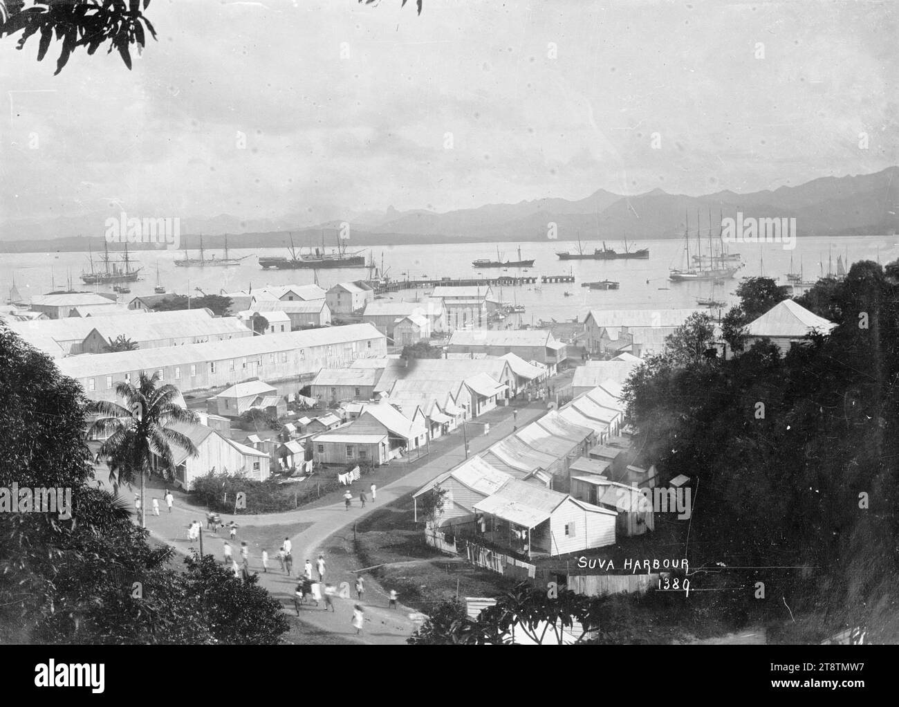 Port de Suva, Viti Levu, Fidji, vue sur le port de Suva depuis un point de vue surplombant les maisons et les bâtiments sur le front de mer. Les navires et les yachts sont ancrés dans le port au début des années 1900 Banque D'Images