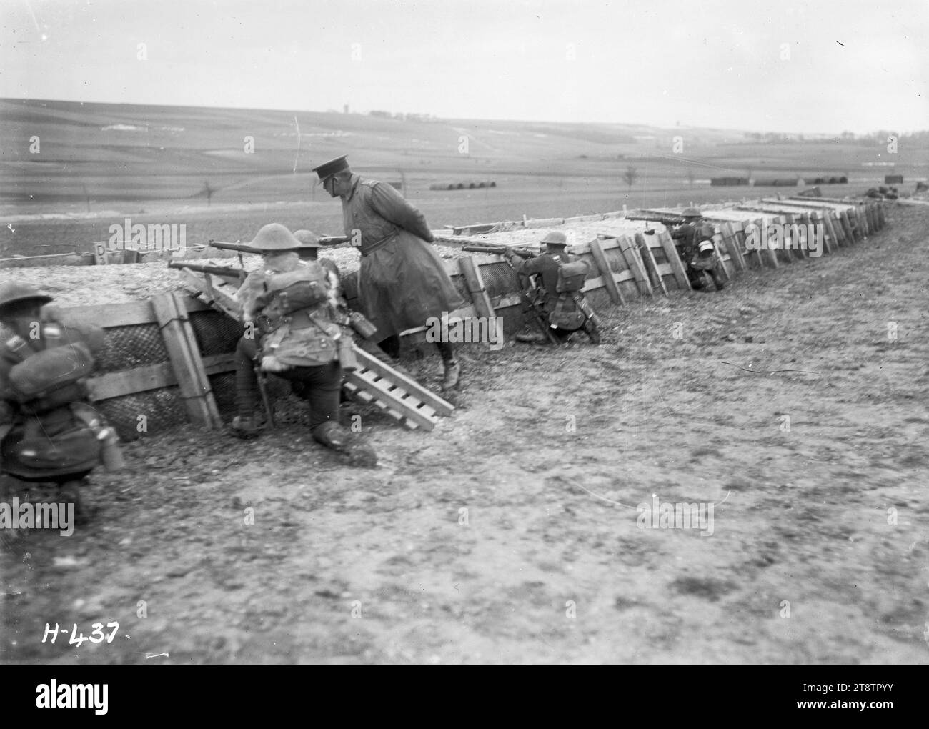 Le commandant néo-zélandais aux opérations sur le terrain en Belgique, première Guerre mondiale, le commandant général (général Russell) observant les opérations sur le terrain des troupes néo-zélandaises en Belgique pendant la première Guerre mondiale Il est debout avec des soldats derrière une fortification. Les soldats accroupis visent avec leurs fusils. Photographie prise près de Dickebusch le 2 mars 1918 Banque D'Images