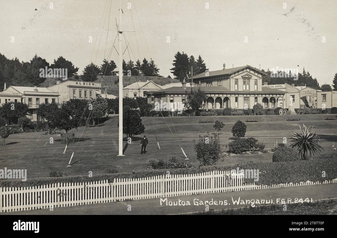 Carte postale. Jardins de Moutoa, Wanganui, Nouvelle-Zélande. F.G.R. série 2441. Carte postale du Dominion de Nouvelle-Zélande ; photographie réelle 1907-1910?, la photographie sur carte postale montre une vue des jardins de Moutoa, avec un mât dans le parc. Derrière se trouvent un Exchange Mart, l'Albion, l'Hôtel commercial, les écuries (à l'extrême droite) et le palais de justice Banque D'Images