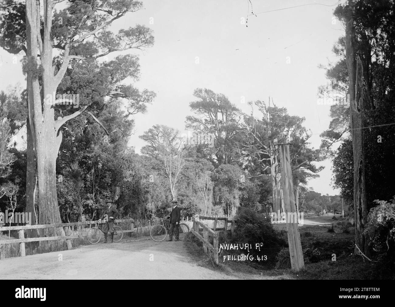 Awahuri Road, Manawatu, Awahuri Road, Manawatu, circa 1910. Deux hommes non identifiés avec des vélos se tiennent sur un pont au-dessus d'un ravin étroit. Photographié Banque D'Images
