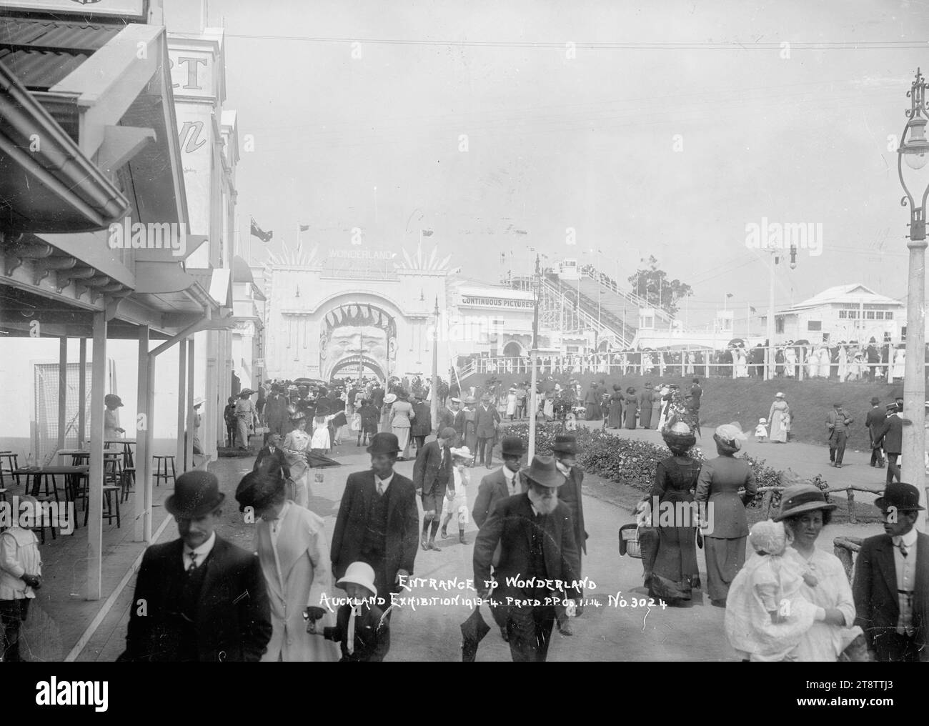 Vue de l'entrée de Wonderland, Auckland, exposition de Nouvelle-Zélande, Auckland, domaine de Nouvelle-Zélande, vue prise en regardant vers le chemin d'entrée (un homme avec sa bouche grande ouverte), avec la piscine et la chute d'eau sur le côté droit. Les gens sont au premier plan marchant vers et depuis Wonderland. Les gens peuvent être vus sur le côté droit regardant l'activité dans la zone de la piscine et en haut de la chute d'eau où le tour commence. P, 1 janvier 1914 à l'exposition d'Auckland, Nouvelle-Zélande, Auckland, domaine de Nouvelle-Zélande Banque D'Images