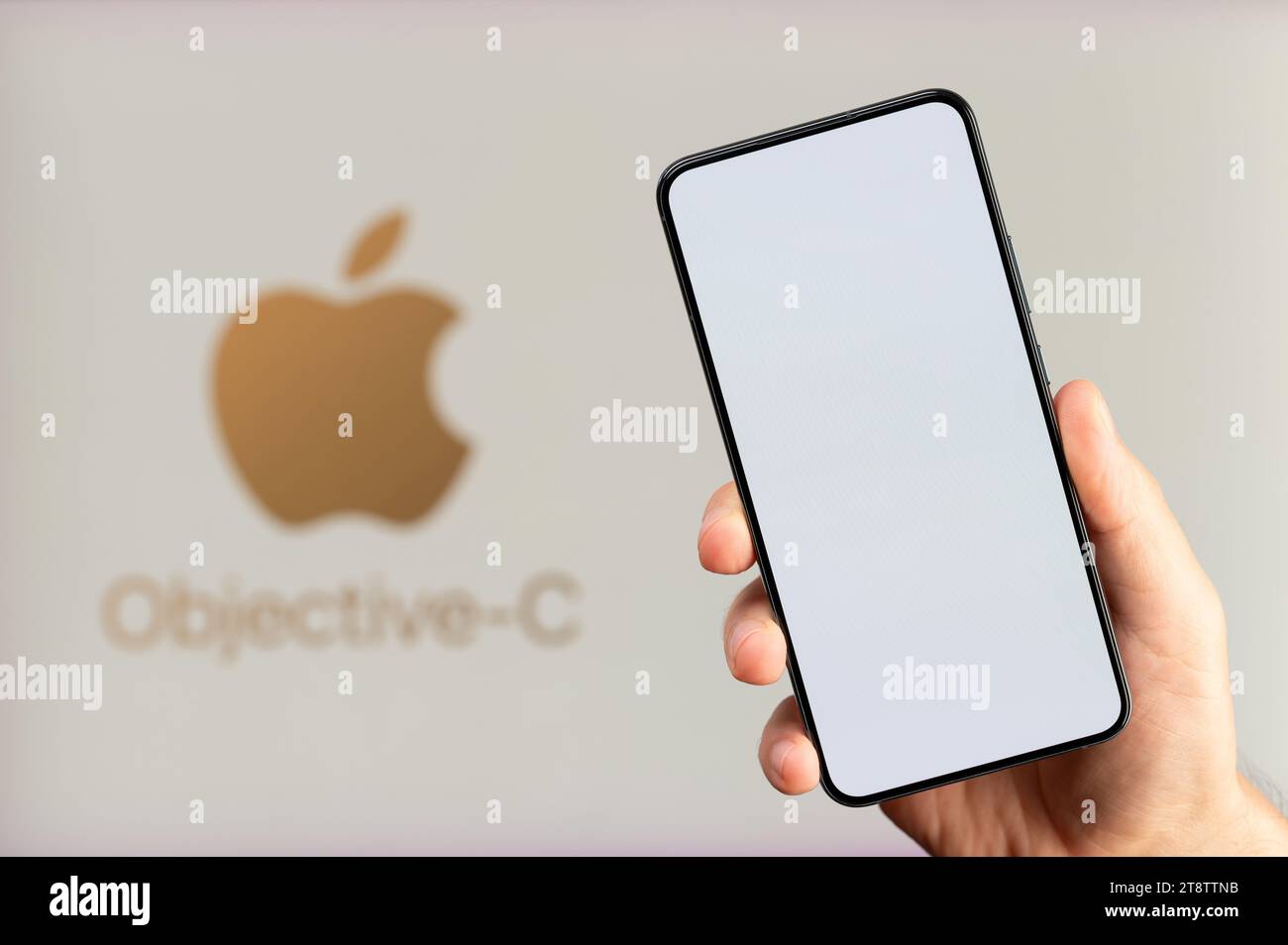 New York, USA - 15 novembre 2023 : création d'une application mobile avec un fond objective-C avec un écran propre de smartphone en main Banque D'Images New York, USA - 15 novembre 2023 : création d'une application mobile avec un fond objective-C avec un écran propre de smartphone en main Banque D'Images
