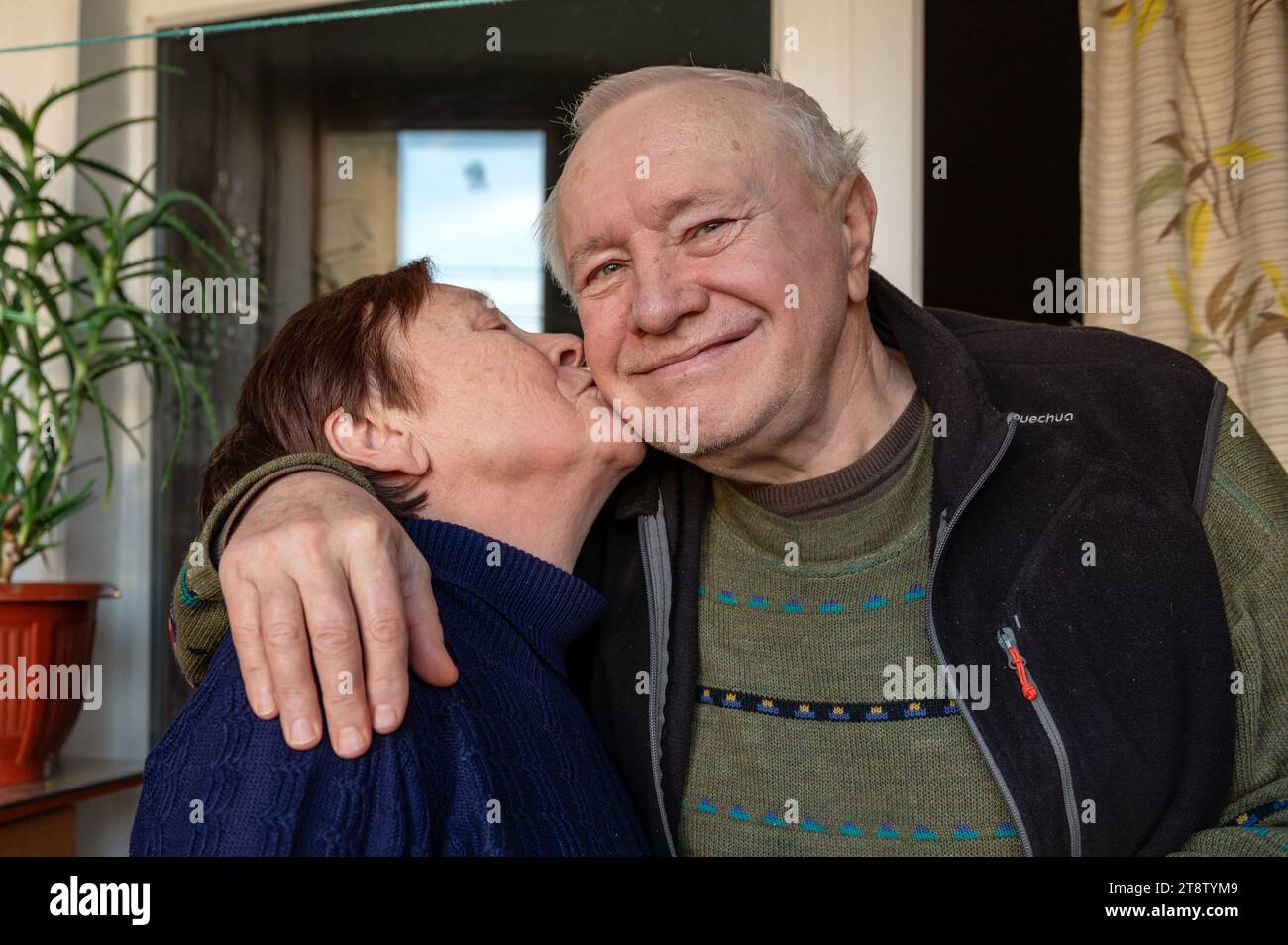 Belle femme âgée embrassant son mari bien-aimé. Une femme âgée embrasse amoureusement son mari sur la joue Banque D'Images