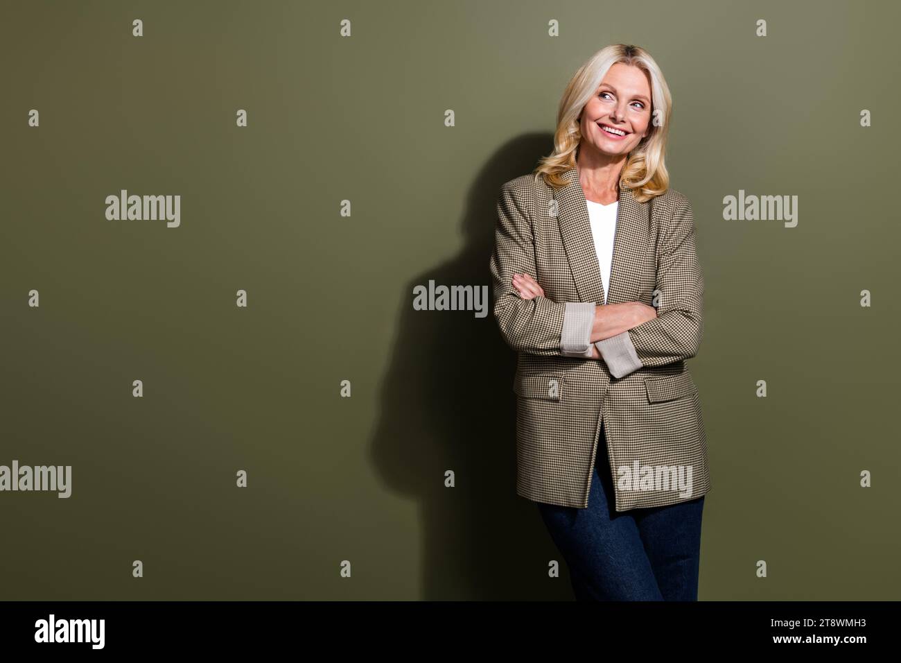 Photo de femme d'affaires senior confiant souriant les bras croisés à la recherche de nouveaux défis idées intelligentes isolées sur fond de couleur kaki Banque D'Images