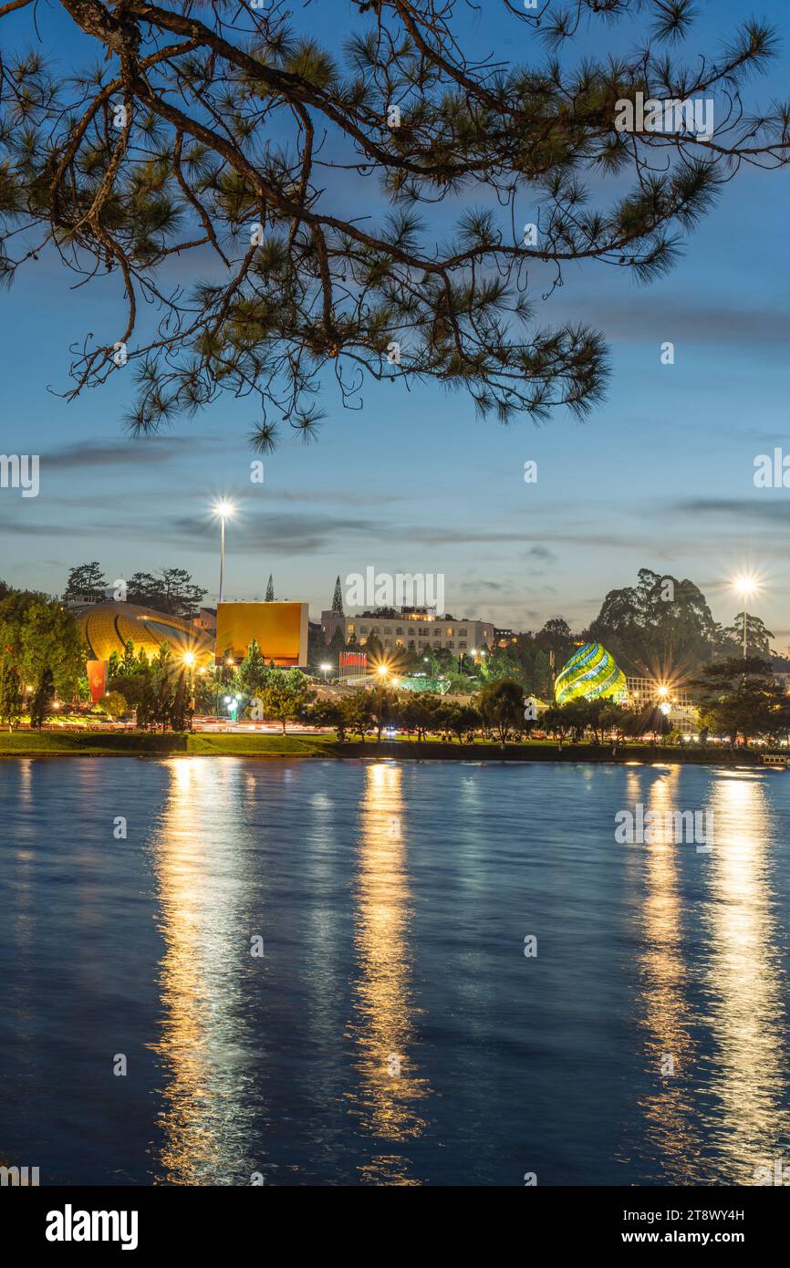 Vue sur le coucher du soleil sur le lac Xuan Huong, loin est Da Lat City avec des bâtiments de développement, transport, marché. Ville touristique avec place centrale de Da Lat Banque D'Images