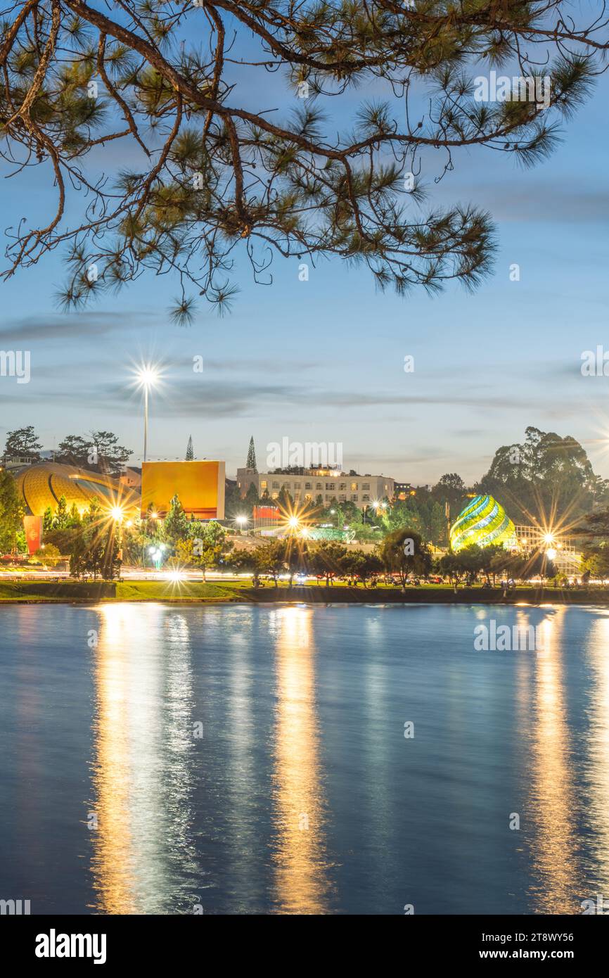 Vue sur le coucher du soleil sur le lac Xuan Huong, loin est Da Lat City avec des bâtiments de développement, transport, marché. Ville touristique avec place centrale de Da Lat Banque D'Images