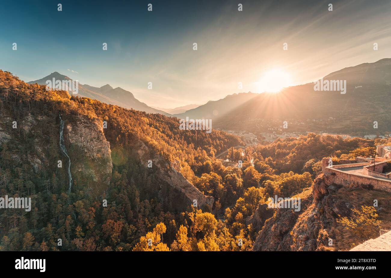 Beau coucher de soleil brille sur la vieille ville historique de Briançon avec forêt d'automne et cascade parmi les Alpes françaises dans les Hautes Alpes, France Banque D'Images