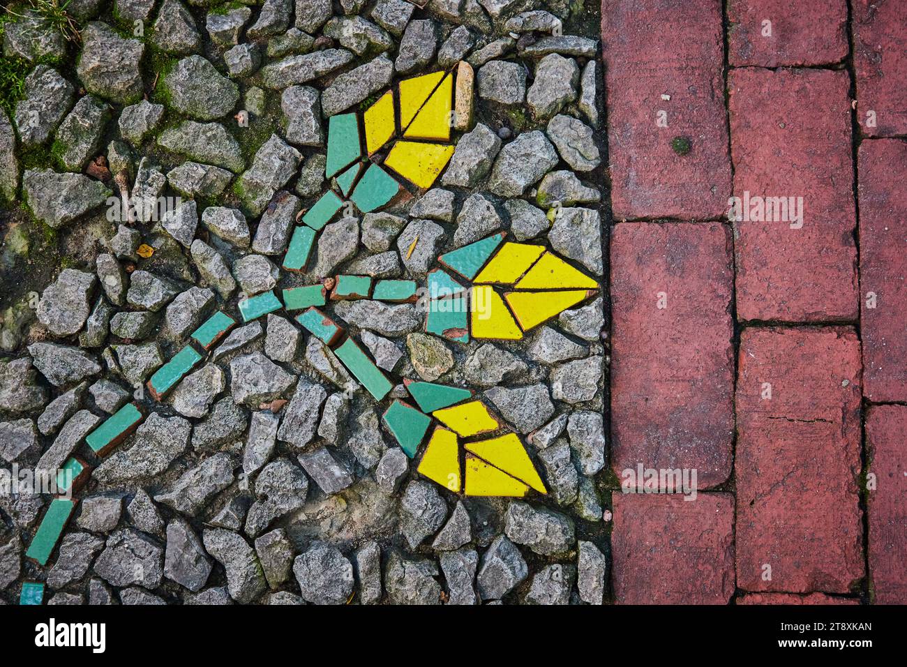 Image divisée, briques rouges à côté de pierres de gravier avec mosaïque abstraite de fleurs peintes motif de roches Banque D'Images