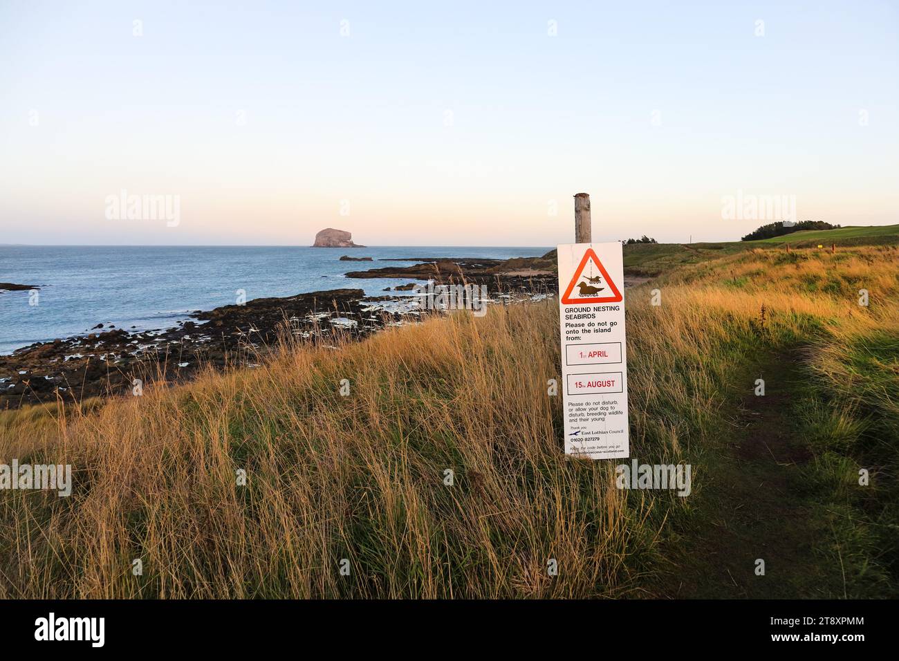 Panneau pour avertir le public afin de protéger les oiseaux nicheurs sur les îles le long de la North Berwick Coast avec Bass Rock en arrière-plan, North Berwick, E Banque D'Images