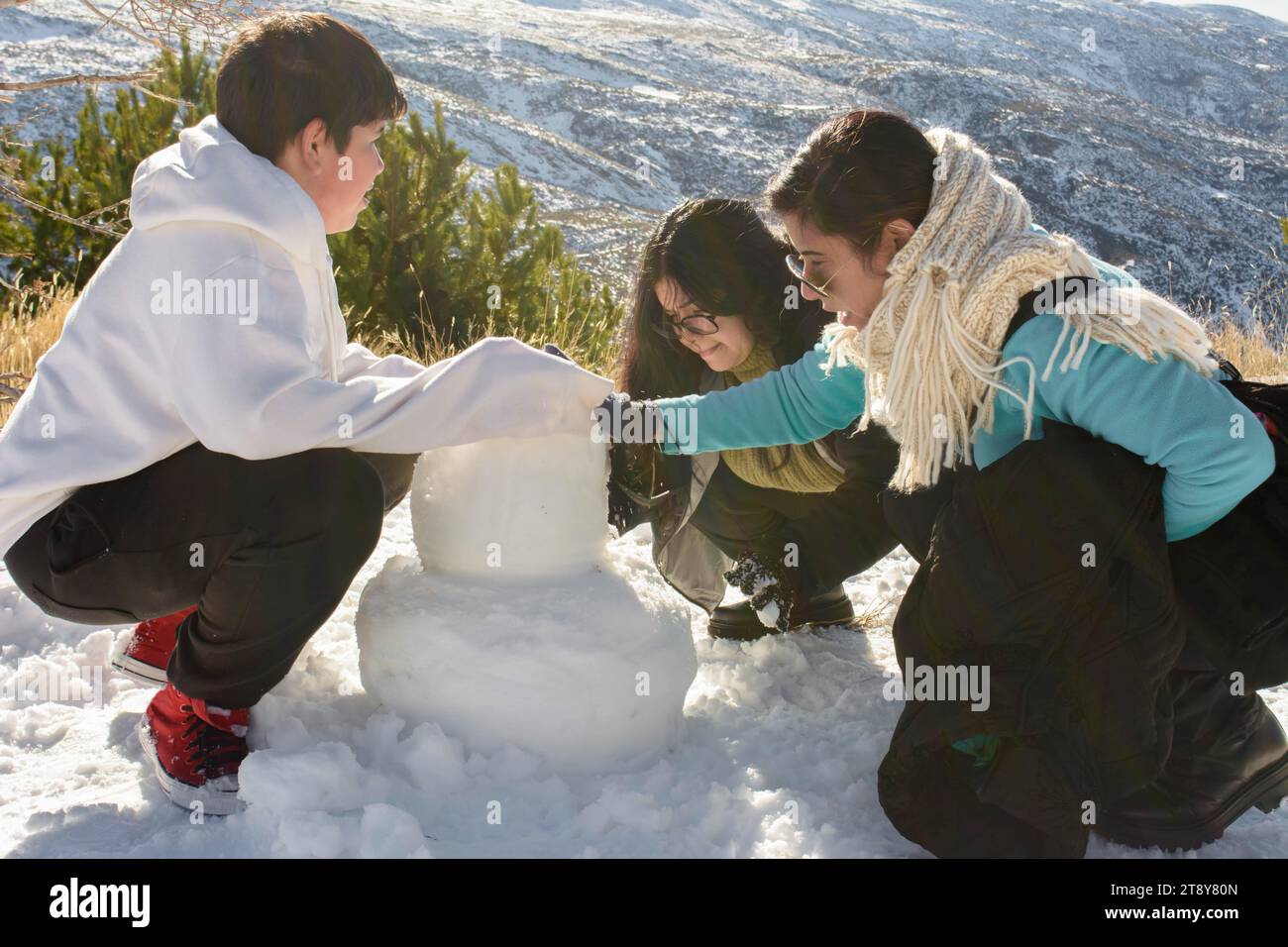 Escapades enneigées dans la Sierra Nevada, Une famille latino-américaine chaleureuse qui construit des souvenirs de bonhomme de neige Banque D'Images