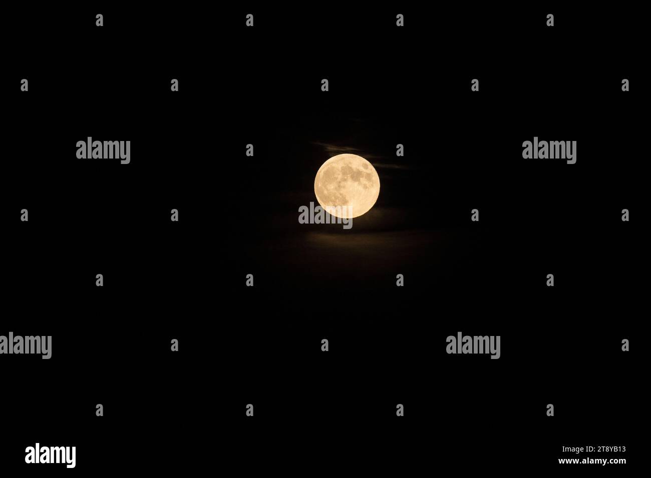 Pleine lune sur le ciel nocturne avec peu de nuages éclairés par le clair de lune fort Banque D'Images