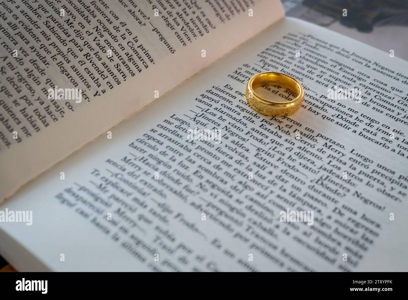 Livre de texte Seigneur des anneaux en espagnol avec l'anneau de pouvoir sur le livre Banque D'Images