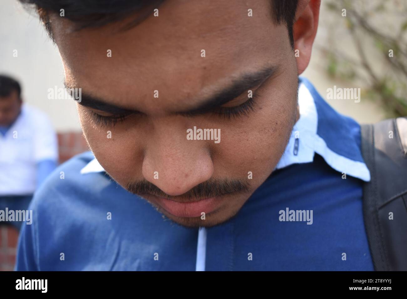 Jeune homme déprimé portrait closeup - Close up visage homme noir dans la caméra - homme indien regardant vers le bas Banque D'Images