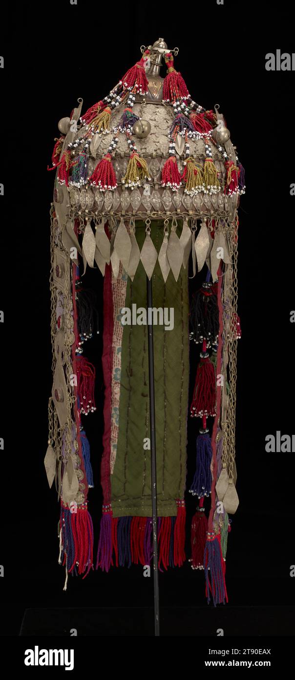 Chapeau, fin 19e-début 20e siècle, 25 1/4 × 7 11/16 × 8 1/4 po. (64,14 × 19,53 × 20,96 cm) (y compris le dos 'queue'), Métal, peau d'animal (?), perles, soie, coton, pierres précieuses de verre, Ouzbékistan ou Afghanistan, 19e-20e siècle, ce chapeau a été fabriqué par des gens du groupe culturel turkmène d'Asie centrale à la fin du XIXe siècle ou au début du XXe siècle. Il aurait été porté par des femmes d'élite dans le cadre d'un ensemble de mariage traditionnel. Le chapeau combine de nombreux matériaux et techniques distinctifs qui sont représentatifs de la culture. Les pompons coupés, les plaques de métal estampées, et l'utilisation de la cornaline Banque D'Images