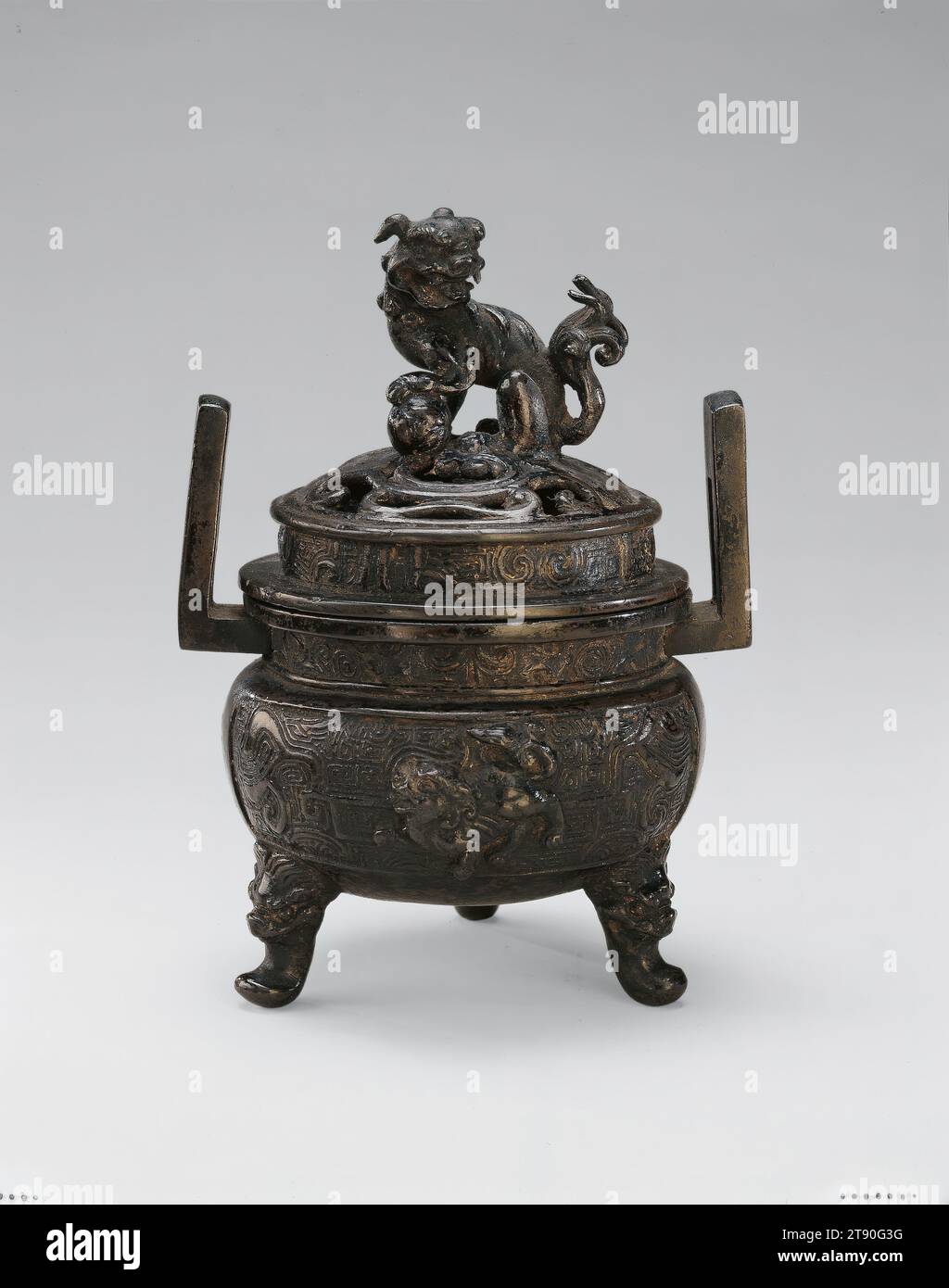 Brûleur d'encens avec lions chinois, 16e siècle, Japonais inconnu, 6 1/8 × 3 15/16 × 3 7/8 po. (15,56 × 10 × 9,84 cm), Bronze, Japon, 16e siècle, ce brûleur d'encens, utilisé dans les rituels bouddhistes, reflète la forme d'un ancien vaisseau chinois à trois pattes appelé un ding et présente plusieurs lions chinois, un animal semi-mythique. Le lion sur le dessus pose sa patte gauche sur un orbe - le joyau du bouddhisme qui accorde des vœux - dans un geste protecteur Banque D'Images