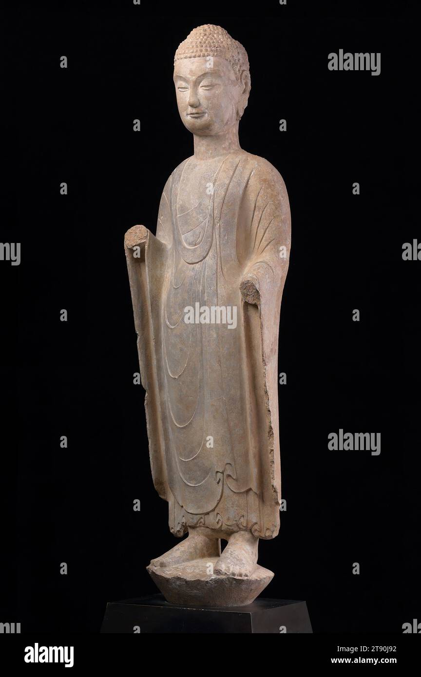 Bouddha Shakyamuni debout, fin du 6e siècle, 45 x 12 3/4 x 9 1/4 po. (114,3 x 32,4 x 23,5 cm) (sans monture), calcaire, Chine, 6e siècle, l'éphémère dynastie Qi du Nord (550-70) est survenue entre deux dynasties, les Wei du Nord (386-535) et les Tang (618-907), longtemps célébrées comme des points forts de l'histoire de l'art bouddhiste chinois Mais la dynastie Qi du Nord a été une époque de changements fondamentaux dans l'imagerie bouddhiste ; les styles sculpturaux nouvellement développés, comme ceux vus dans cette sculpture, ont jeté les bases des réalisations artistiques à venir Banque D'Images