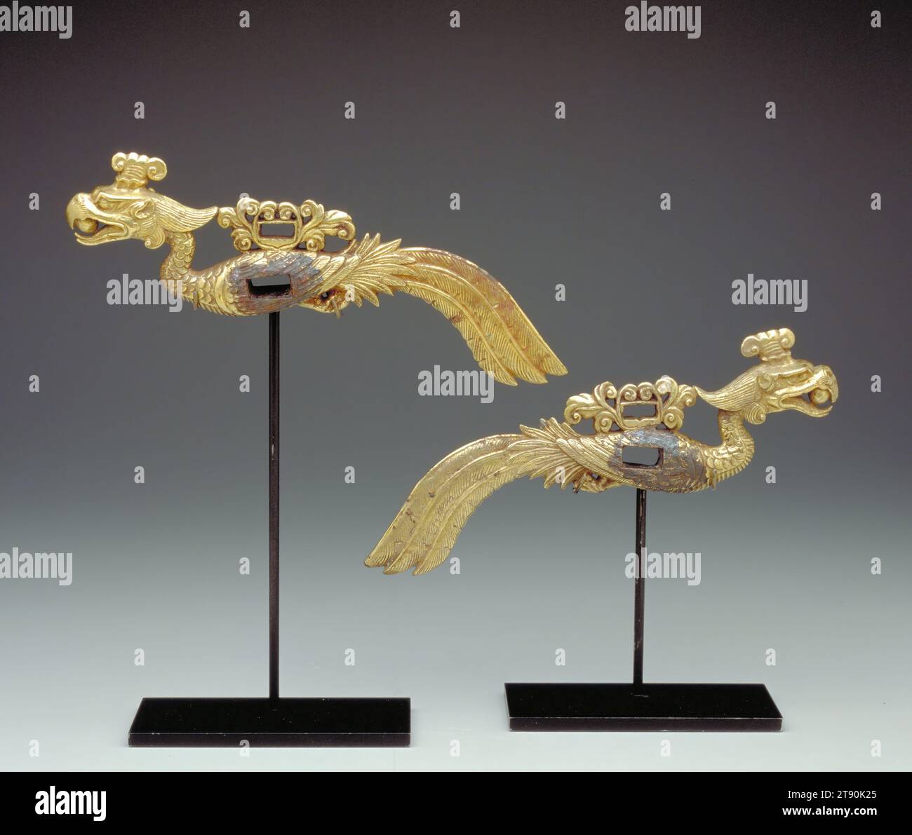 Harnais Trapping, un d'une paire, 10e siècle, H.3-3/4 x W.9-3/8 x D.3/4 po., bronze doré, Chine, 10e siècle, monté à l'origine comme pièces de joue sur la bride d'un cheval, ces gracieux harnais sont chacun coulés sous la forme d'un phénix mythique tenant une perle dans son bec. Le peuple Liao est venu des prairies des steppes du nord pour conquérir le nord de la Chine au Xe siècle (916-1125). Il s'agissait d'éleveurs équestres qui prêtaient une grande attention aux selles et aux harnais de leurs montures prisées. Bien qu'étrangers, les Liao embrassent de nombreux aspects de l'héritage artistique de la Chine Banque D'Images