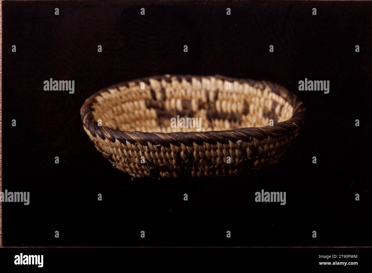 Panier, 20e siècle, 5/8 x 1 1/4 x 2 1/8 po. (1,6 x 3,2 cm), fibres végétales naturelles, États-Unis, 20e siècle, l’offre et la demande du marché qui se sont développées entre les touristes euro-américains et les fabricants de paniers Akimel O’othom et Tohono O’odham démontrent le haut niveau d’ingéniosité et de productivité des tribus. Les articles de nouveauté inventés par les artistes autochtones comprennent des paniers de papier usagé, des effigies animales et humaines, et des miniatures de formes populaires de paniers. Le plus petit panier ici mesure seulement un demi pouce de diamètre. L'utilisation de figures animales et humaines dans la vannerie Banque D'Images