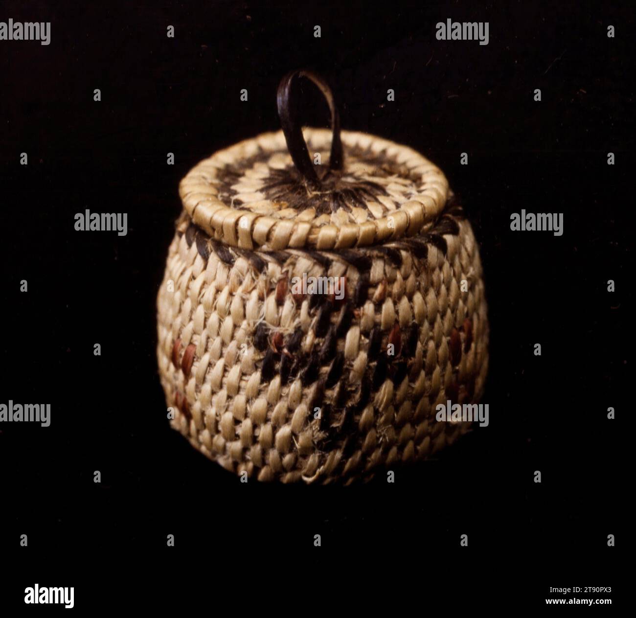 Panier, 20e siècle, 5/8 x 5/8 x 5/8 po. (1,6 x 1,6 x 1,6 cm), fibres végétales naturelles, États-Unis, 20e siècle, l’offre et la demande du marché qui se sont développées entre les touristes euro-américains et les fabricants de paniers Akimel O’othom et Tohono O’odham démontrent le haut niveau d’ingéniosité et de productivité des tribus. Les articles de nouveauté inventés par les artistes autochtones comprennent des paniers de papier usagé, des effigies animales et humaines, et des miniatures de formes populaires de paniers. Le plus petit panier ici mesure seulement un demi pouce de diamètre. L'utilisation de figures animales et humaines dans la vannerie Banque D'Images