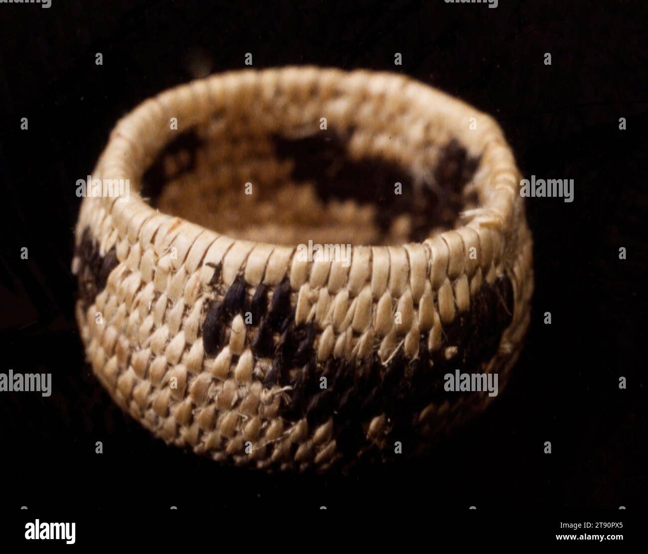 Panier, 20e siècle, 1/2 x 3/4 x 3/4 po. (1,3 x 1,9 x 1,9 cm), fibres végétales naturelles, États-Unis, 20e siècle, l’offre et la demande du marché qui se sont développées entre les touristes euro-américains et les fabricants de paniers Akimel O’othom et Tohono O’odham démontrent le haut niveau d’ingéniosité et de productivité des tribus. Les articles de nouveauté inventés par les artistes autochtones comprennent des paniers de papier usagé, des effigies animales et humaines, et des miniatures de formes populaires de paniers. Le plus petit panier ici mesure seulement un demi pouce de diamètre. L'utilisation de figures animales et humaines dans la vannerie Banque D'Images