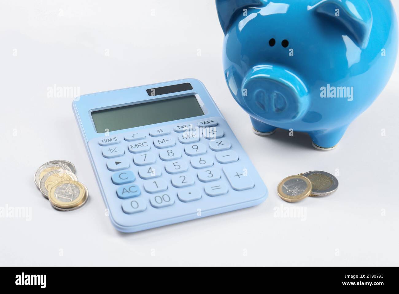 Calculatrice, tirelire et pièces de monnaie sur fond blanc. Concept de retraite Banque D'Images