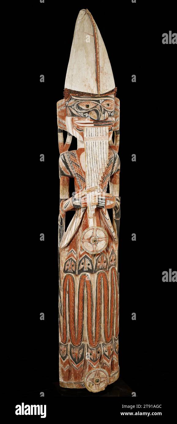 Figurine Malagan, c. 1890, inconnue, 78 x 13 1/2 x 12 po. (198,12 x 34,29 x 30,48 cm), Bois, pigment, coquille, Papouasie-Nouvelle-Guinée, 19e siècle, cette grande figure tient un instrument appelé katoviso, qui comprend un groupe de pipes de bambou qui sont jouées en soufflant à travers le dessus. Le chapeau de pluie du Piper, fait d'une feuille de pandan, est typique pour les femmes. Les sculptures stylisées de serpents qui composent la jupe représentent la connexion de la femme au monde spirituel. Les serpents apparaissent fréquemment dans l'art de la Nouvelle-Irlande en raison de leurs pouvoirs surnaturels. Cette figure représente probablement un ancêtre du clan Banque D'Images