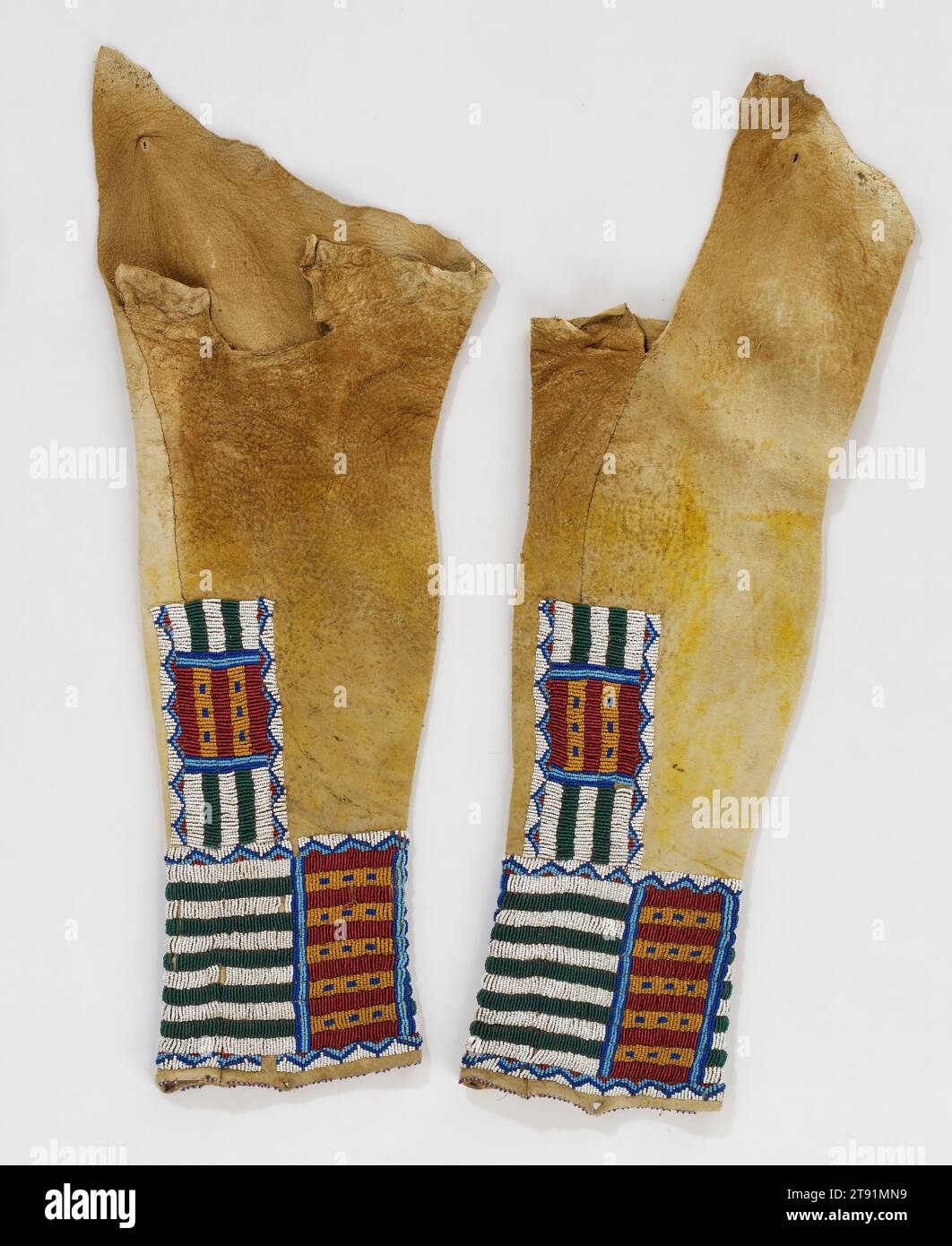 Paire de leggings pour femme, c. 1880, Cacher, perles, pigment, États-Unis, 19e siècle, parmi les Tsististas, les femmes travaillaient traditionnellement des peaux pour les vêtements et autres nécessités. Les dessins ont ensuite été ajoutés par des membres de sociétés de femmes exclusives qui ont réglementé leur signification et leur utilisation. Les lignes perlées ici, par exemple, représentaient traditionnellement les honneurs de guerre du porteur ou de sa famille, un motif souvent répété sur les chemises et leggings des hommes. Cependant, au moment où ces leggings ont été créés, le symbolisme des lignes a probablement été davantage utilisé pour leur effet décoratif. Banque D'Images